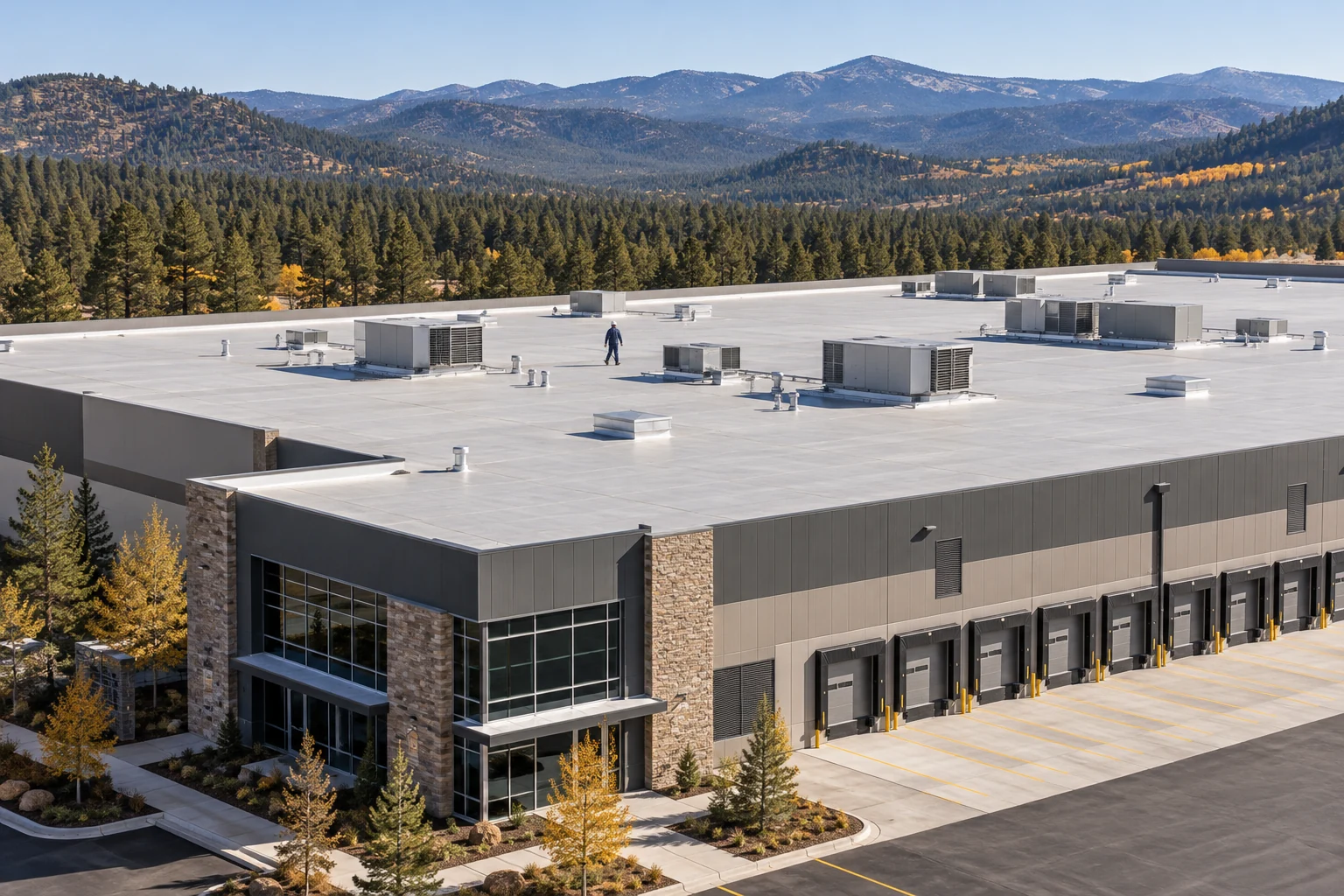 Expansive commercial membrane roof with an inspector and rooftop mechanical equipment